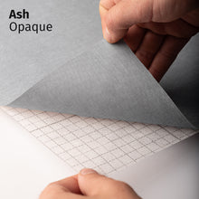 Afbeelding in Gallery-weergave laden, Ash Opaque adhesive textile film with grid-lined non-woven backing, shown being peeled back to demonstrate its opaque appearance and easy application.