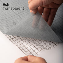 Afbeelding in Gallery-weergave laden, Ash Transparent adhesive textile film with grid-lined clear backing, shown being peeled back to demonstrate its semi-transparent finish and easy application.