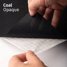 Cargar imagen en el visor de la galería, Coal Opaque adhesive textile film with grid-lined non-woven backing, shown being peeled back to demonstrate its opaque appearance and easy application.
