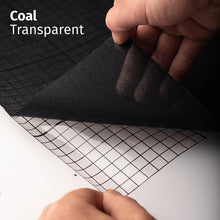 Cargar imagen en el visor de la galería, Coal Transparent adhesive textile film with grid-lined clear backing, shown being peeled back to demonstrate its semi-transparent finish and easy application.